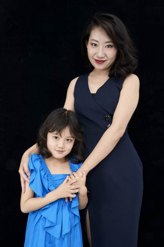 黑色背景的美丽妈妈与可爱女儿亲子人像图片