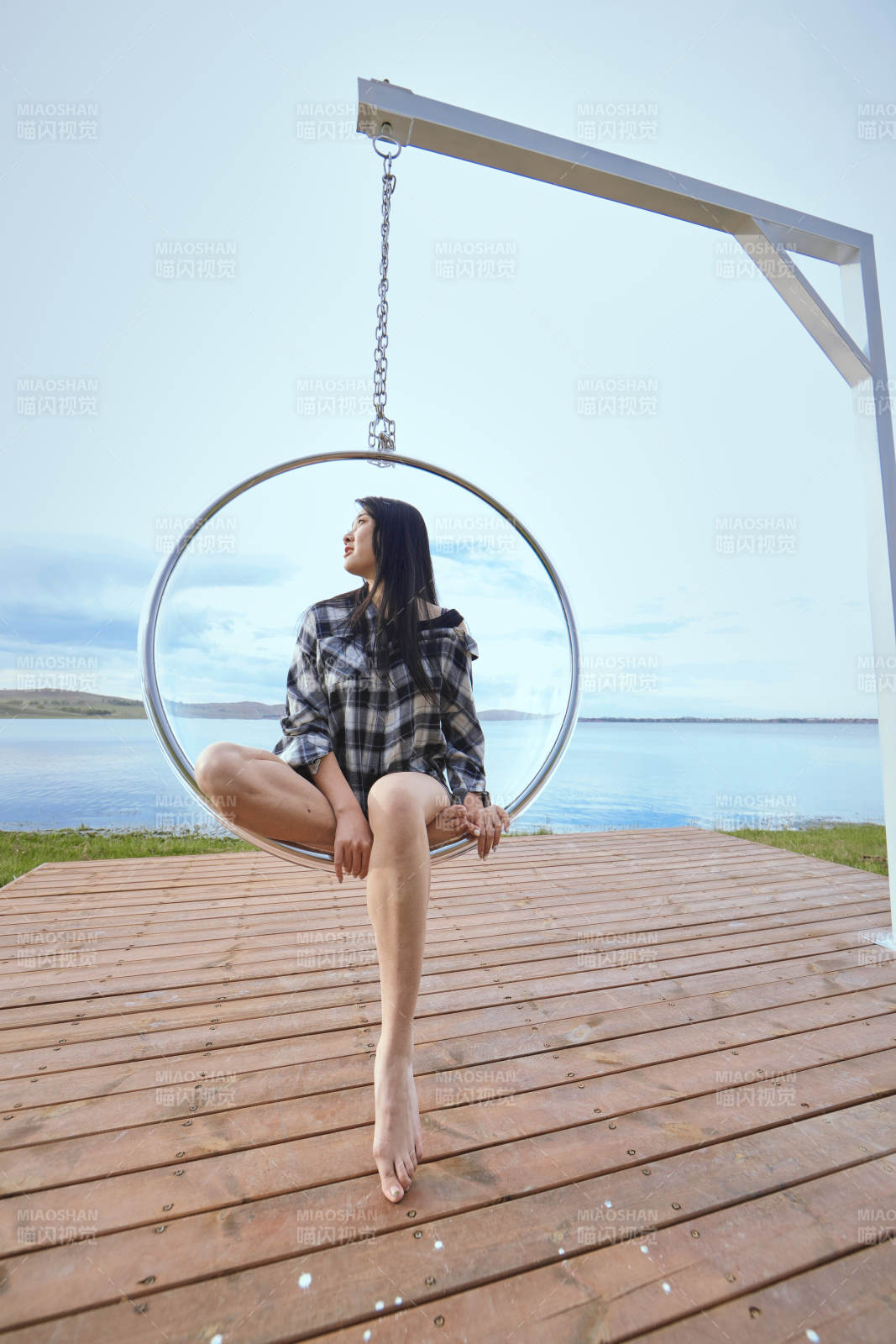 草原湖畔坐在透明秋千里的亚洲年轻女性人像图片