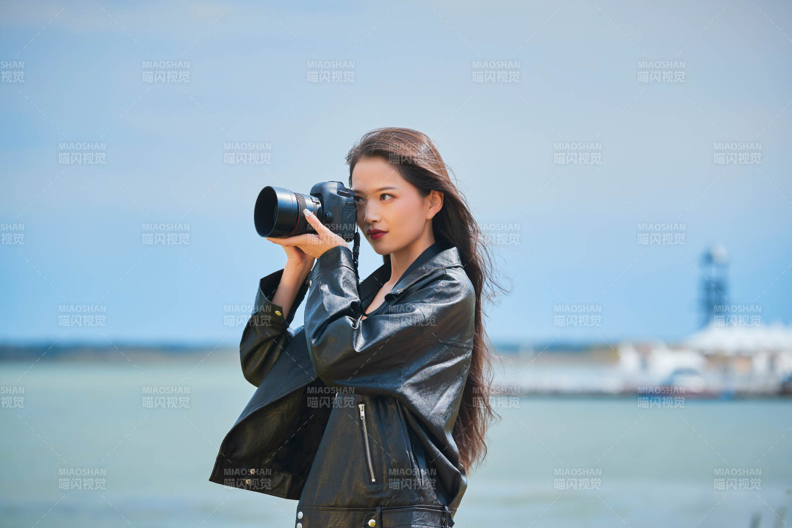 户外湖畔进行拍摄的亚洲青年女性摄影师图片