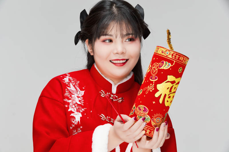 怀抱爆竹身穿喜庆汉服的可爱少女图片