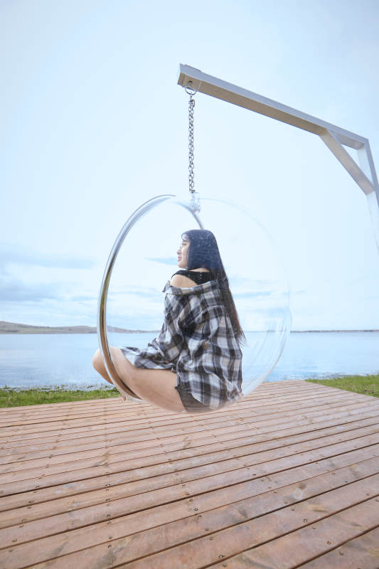 草原湖畔坐在透明秋千里的亚洲年轻女性人像图片