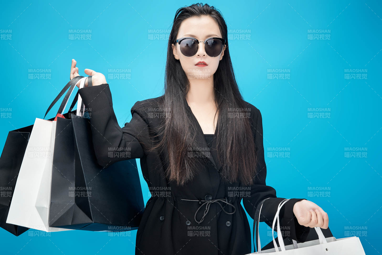 青蓝色背景下手提购物袋的亚洲时尚少女图片