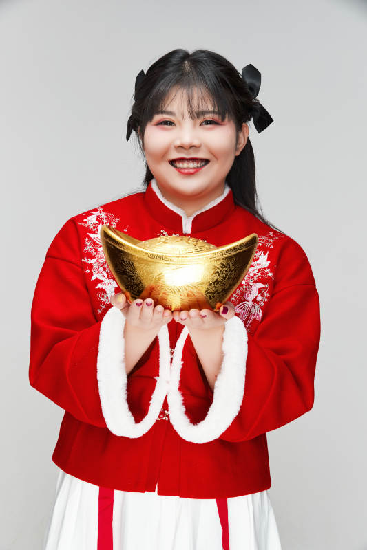 手捧金元宝身穿喜庆汉服的可爱少女图片