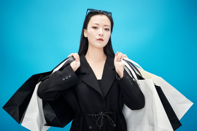 青蓝色背景下手提购物袋的亚洲时尚少女图片