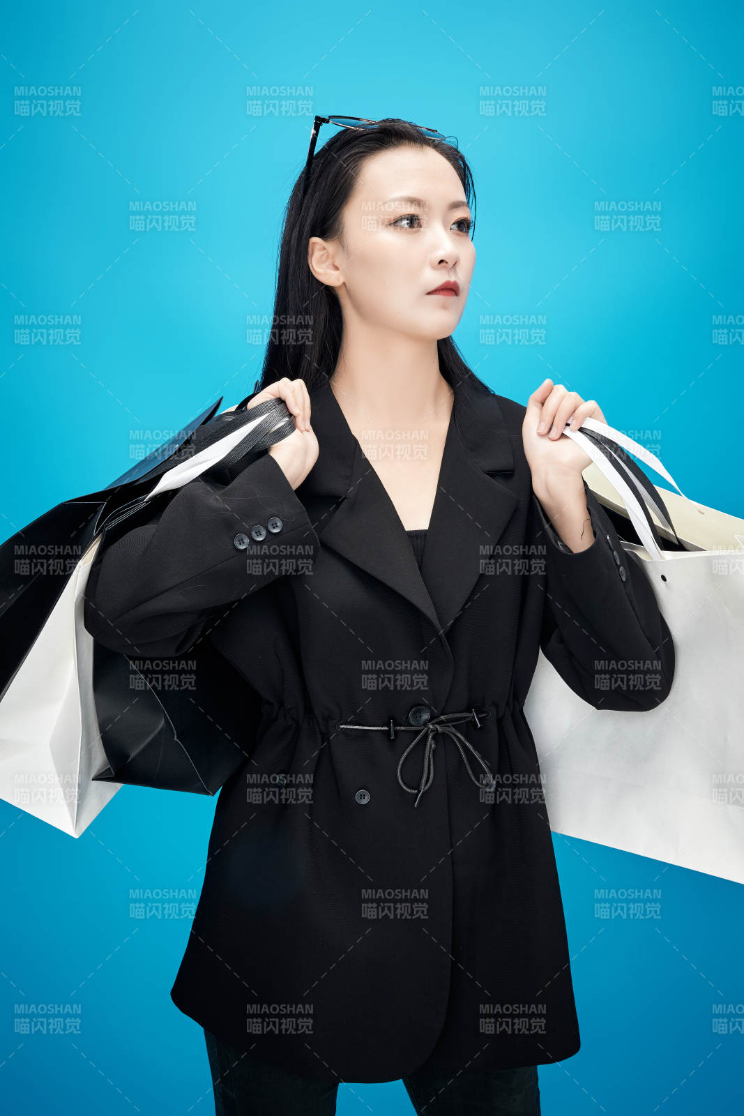 青蓝色背景下手提购物袋的亚洲时尚少女图片