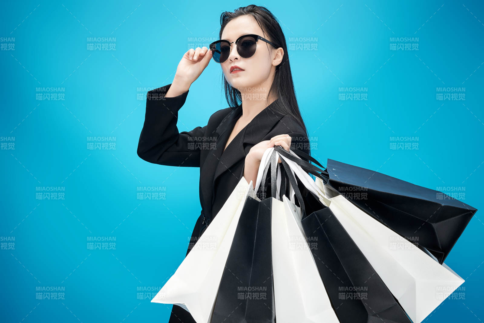 青蓝色背景下手提购物袋的亚洲时尚少女图片
