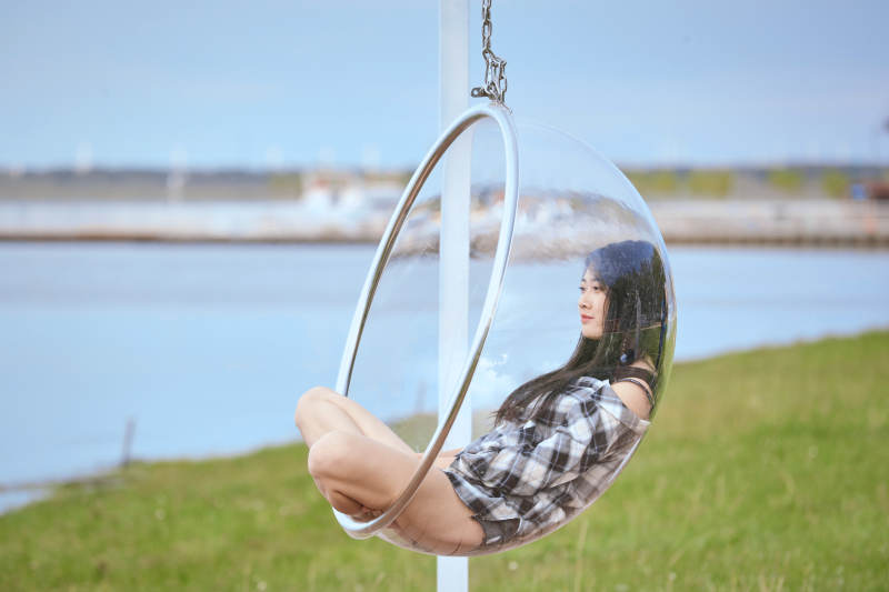 草原湖畔坐在透明秋千里的亚洲年轻女性人像图片