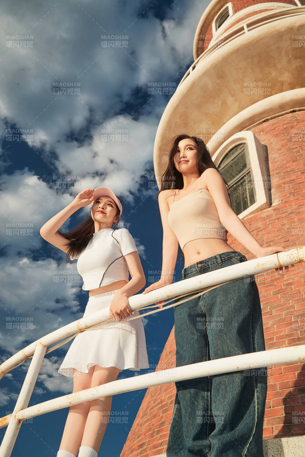 盛夏在景区湖边灯塔上拍照游玩的美女们图片