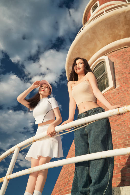 盛夏在景区湖边灯塔上拍照游玩的美女们图片