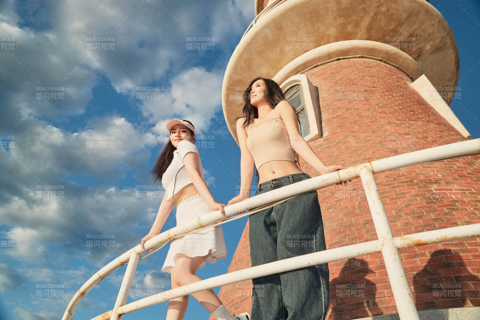 盛夏在景区湖边灯塔上拍照游玩的美女们图片