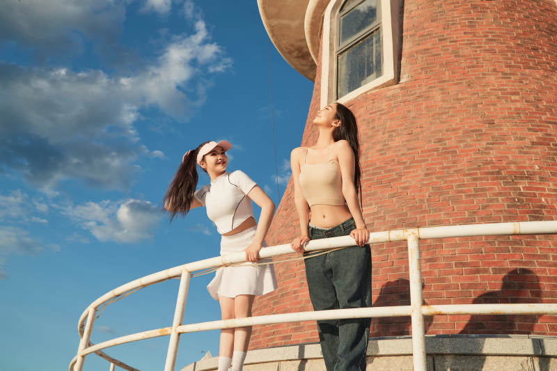 盛夏在景区湖边灯塔上拍照游玩的美女们图片