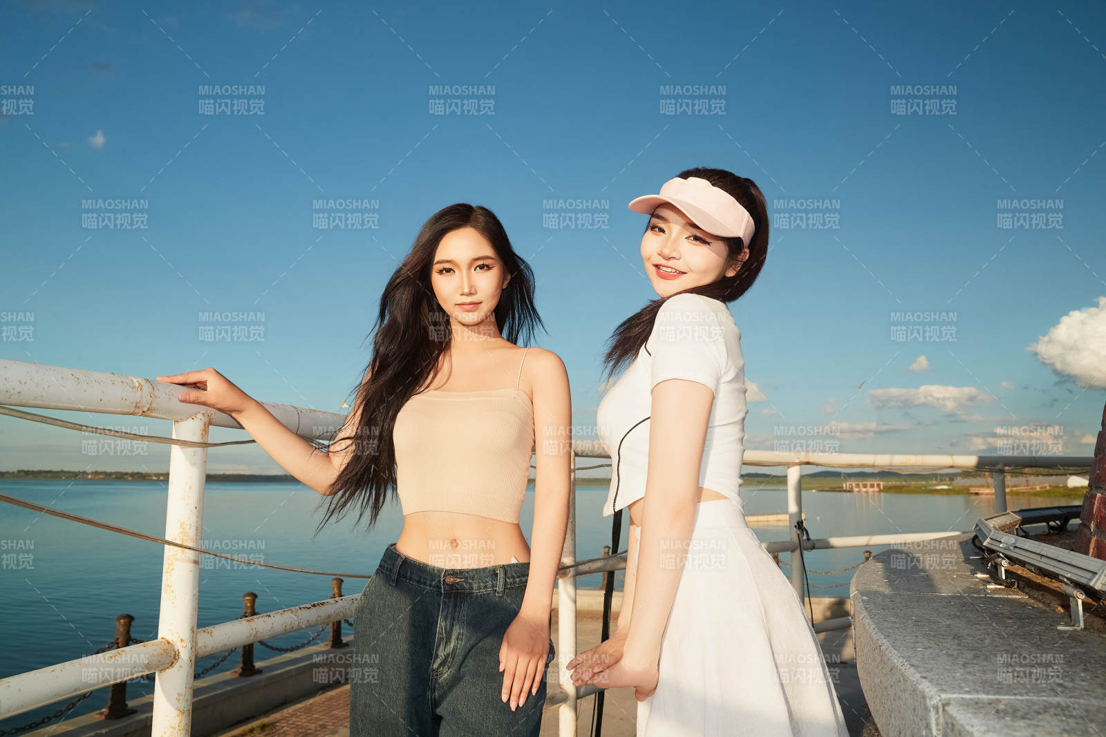 盛夏在景区湖边灯塔上拍照游玩的美女们图片