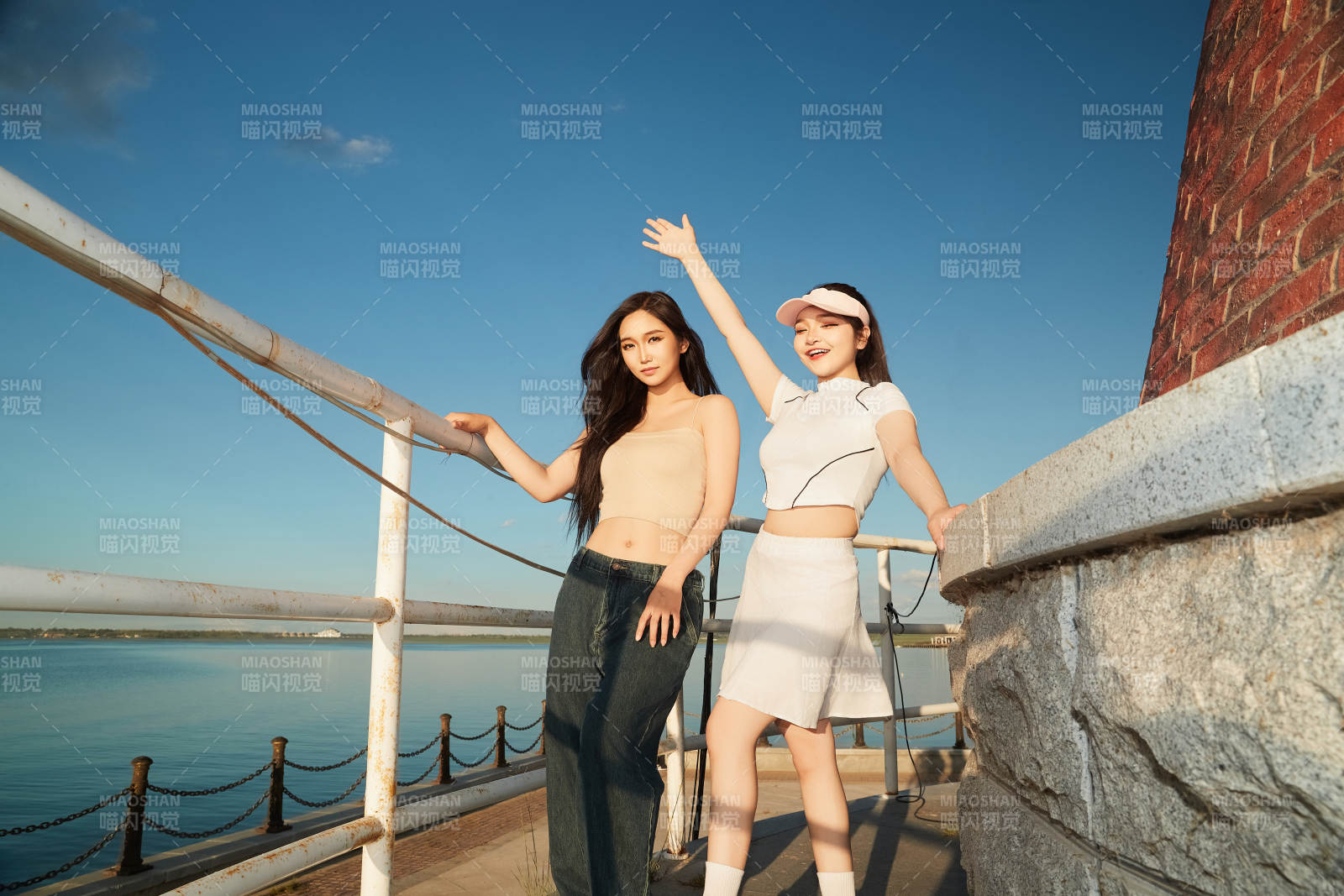 盛夏在景区湖边灯塔上拍照游玩的美女们图片