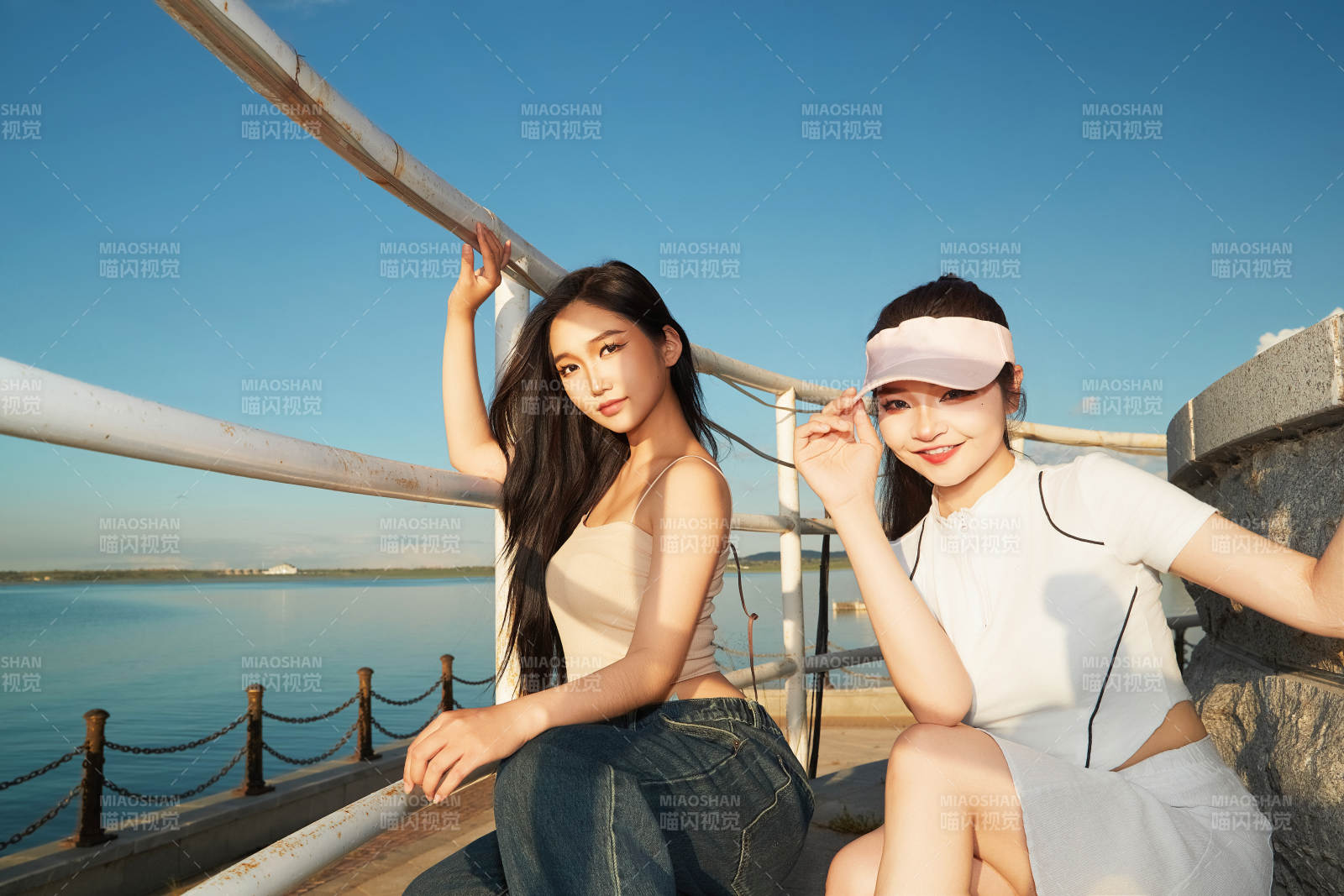 盛夏在景区湖边灯塔上拍照游玩的美女们图片