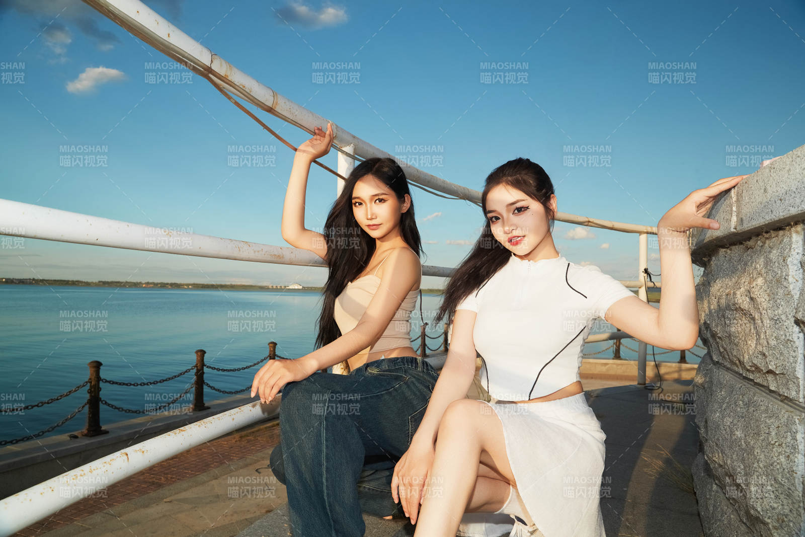 盛夏在景区湖边灯塔上拍照游玩的美女们图片