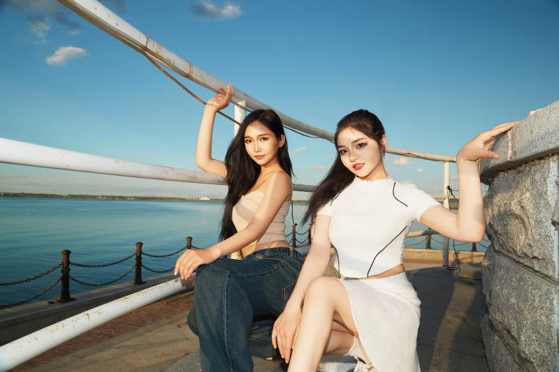 盛夏在景区湖边灯塔上拍照游玩的美女们图片