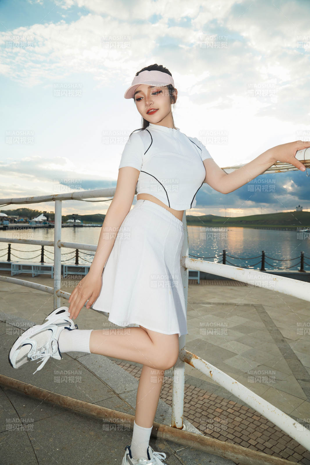 盛夏在景区湖边灯塔上拍照游玩的美女图片