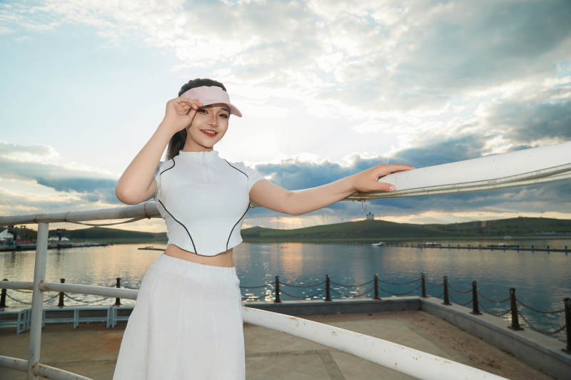 盛夏在景区湖边灯塔上拍照游玩的美女图片