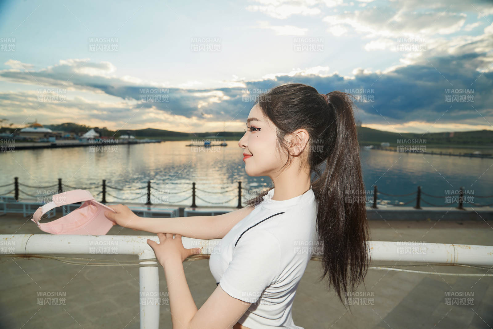 盛夏在景区湖边灯塔上拍照游玩的美女图片