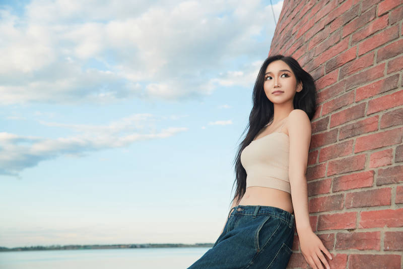 盛夏在景区湖边灯塔上拍照游玩的美女图片