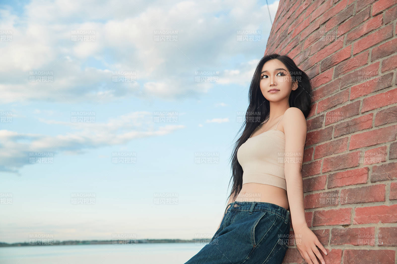 盛夏在景区湖边灯塔上拍照游玩的美女图片