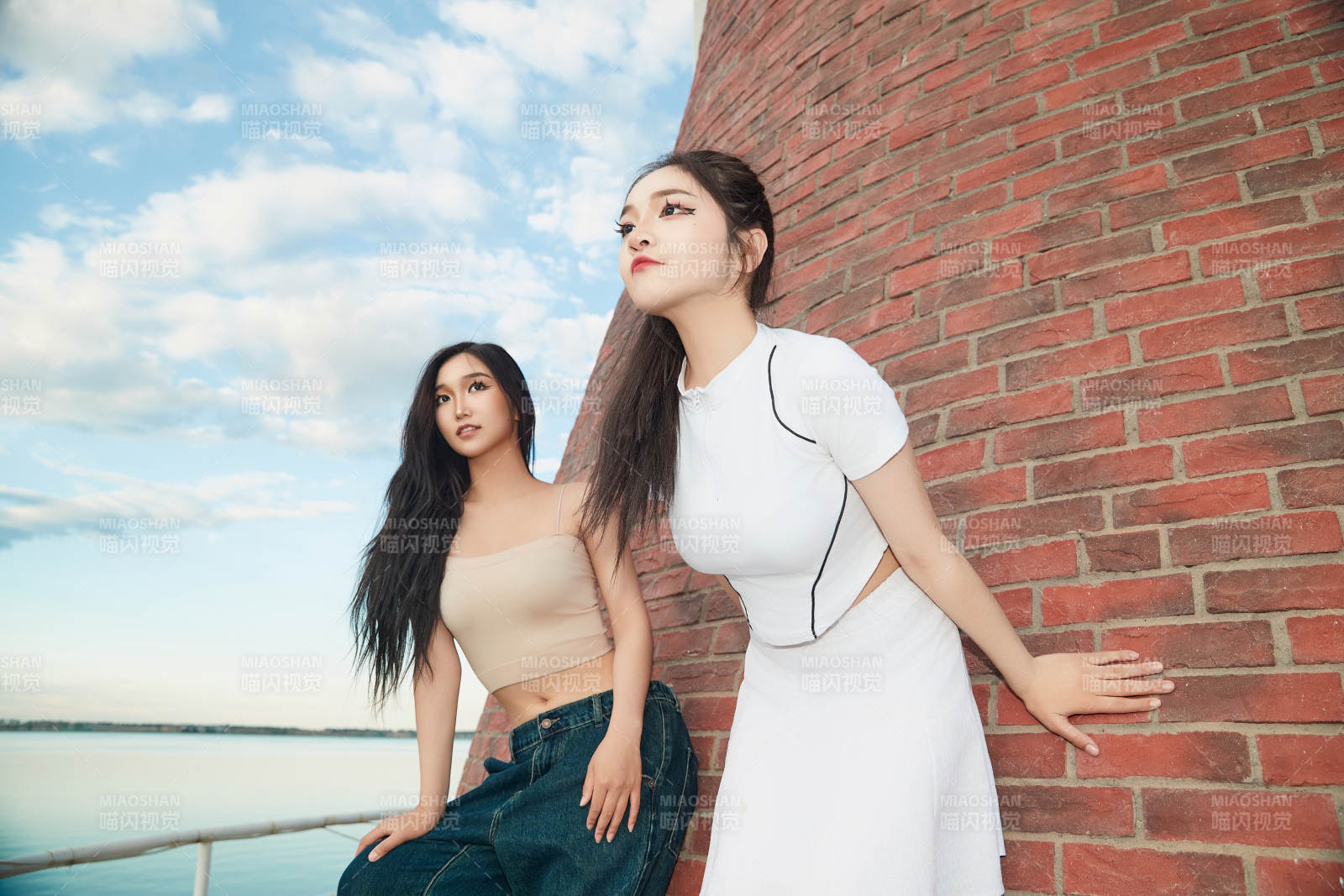 盛夏在景区湖边灯塔上拍照游玩的美女们图片