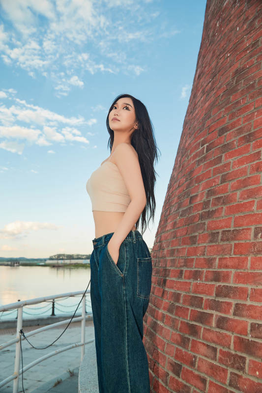 盛夏在景区湖边灯塔上拍照游玩的美女图片