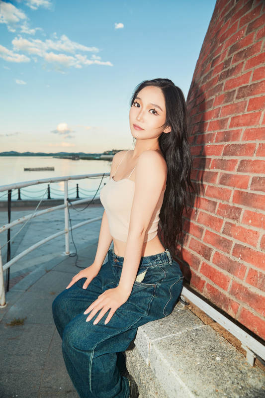 盛夏在景区湖边灯塔上拍照游玩的美女图片