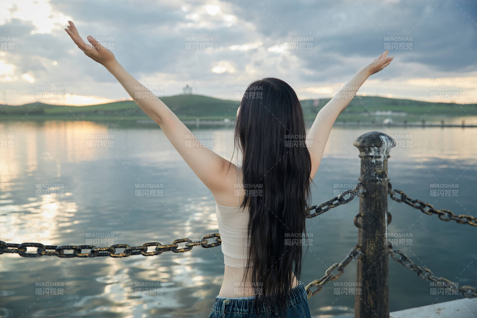 傍晚在湖边欣赏风景拍照的亚洲美女图片