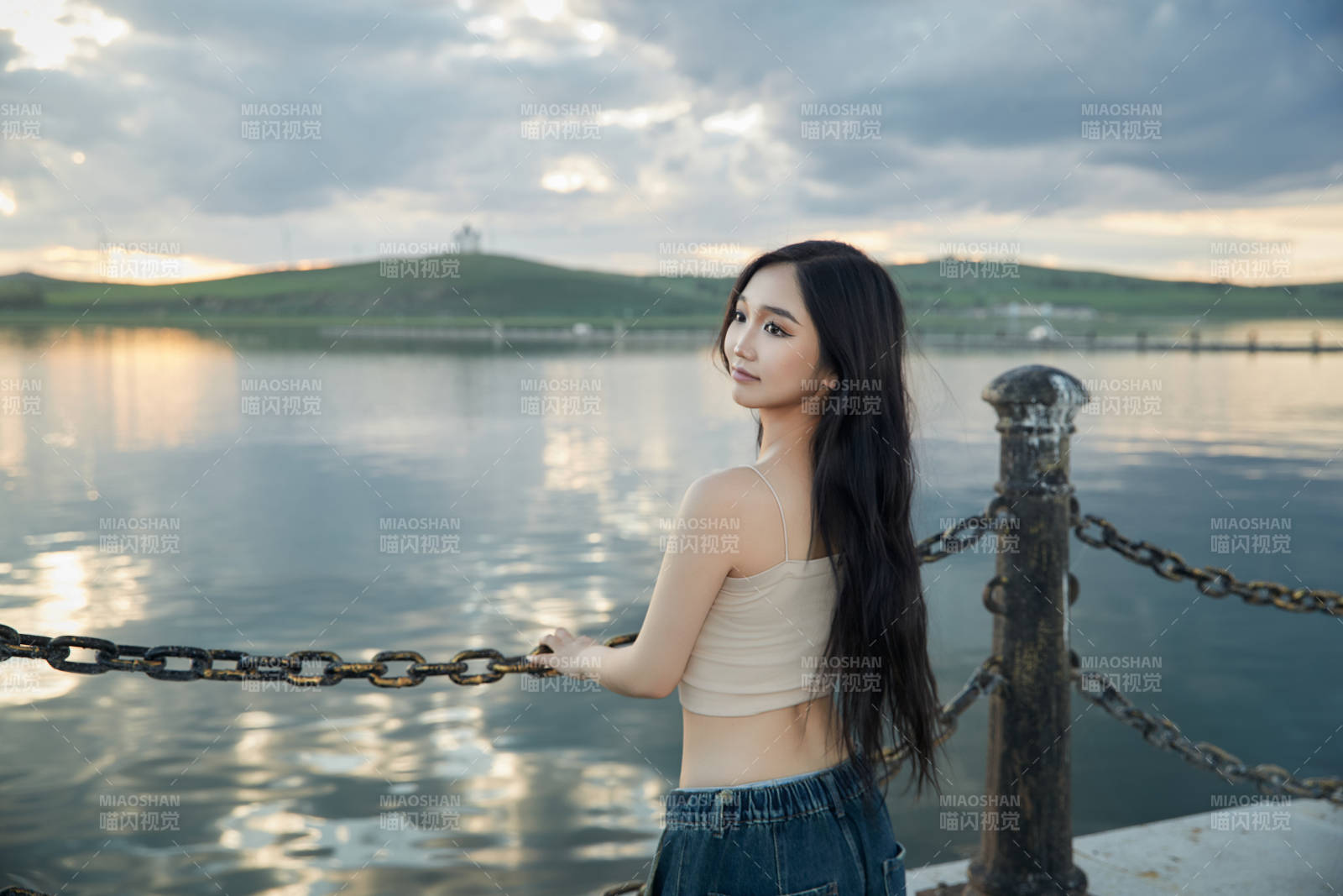 傍晚在湖边欣赏风景拍照的亚洲美女图片