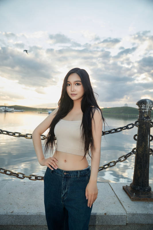 傍晚在湖边欣赏风景拍照的亚洲美女图片