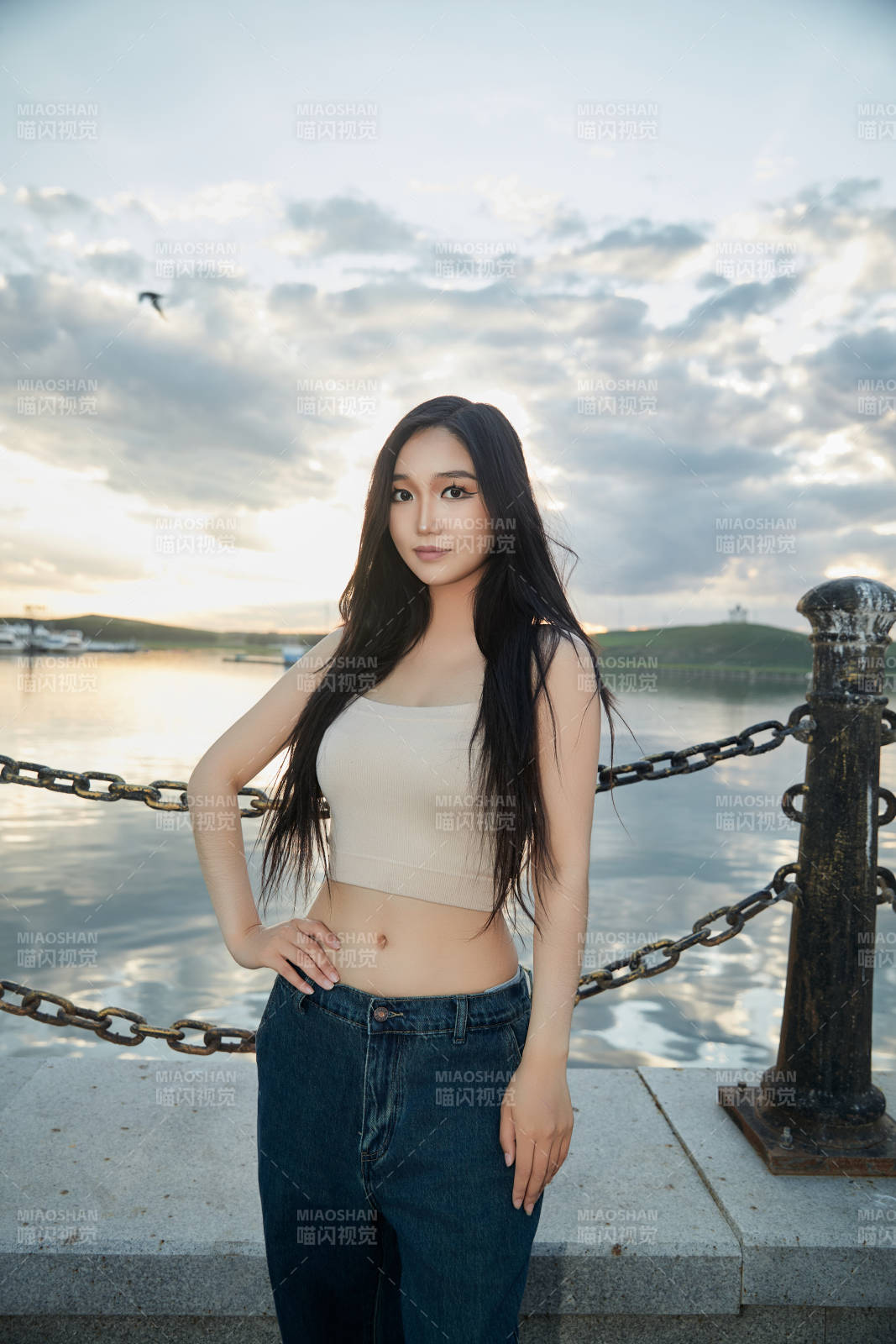 傍晚在湖边欣赏风景拍照的亚洲美女图片