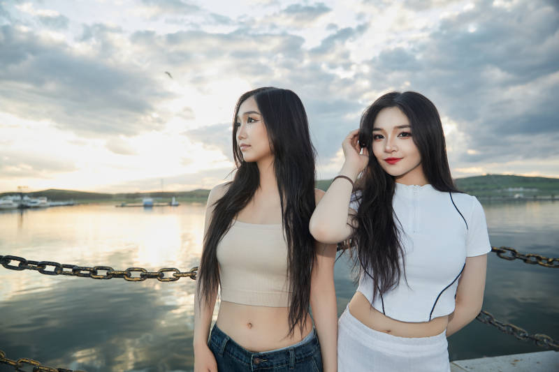 傍晚在湖边欣赏风景拍照的亚洲美女们图片