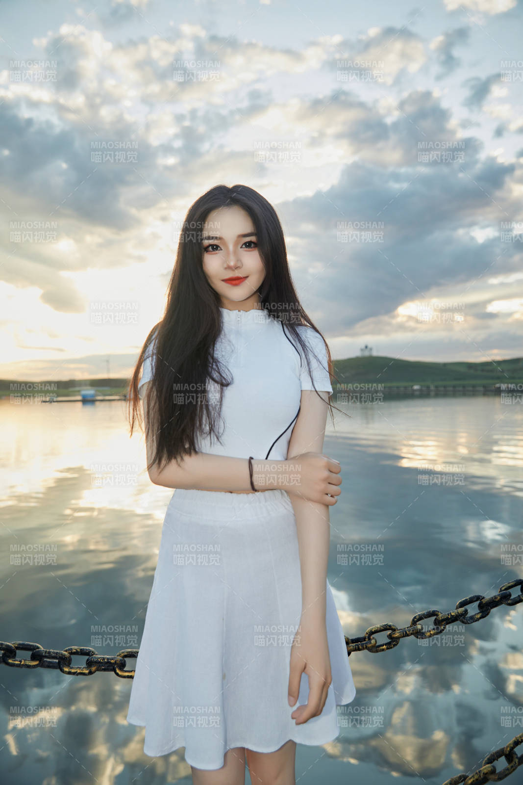 傍晚在湖边欣赏风景拍照的亚洲美女图片