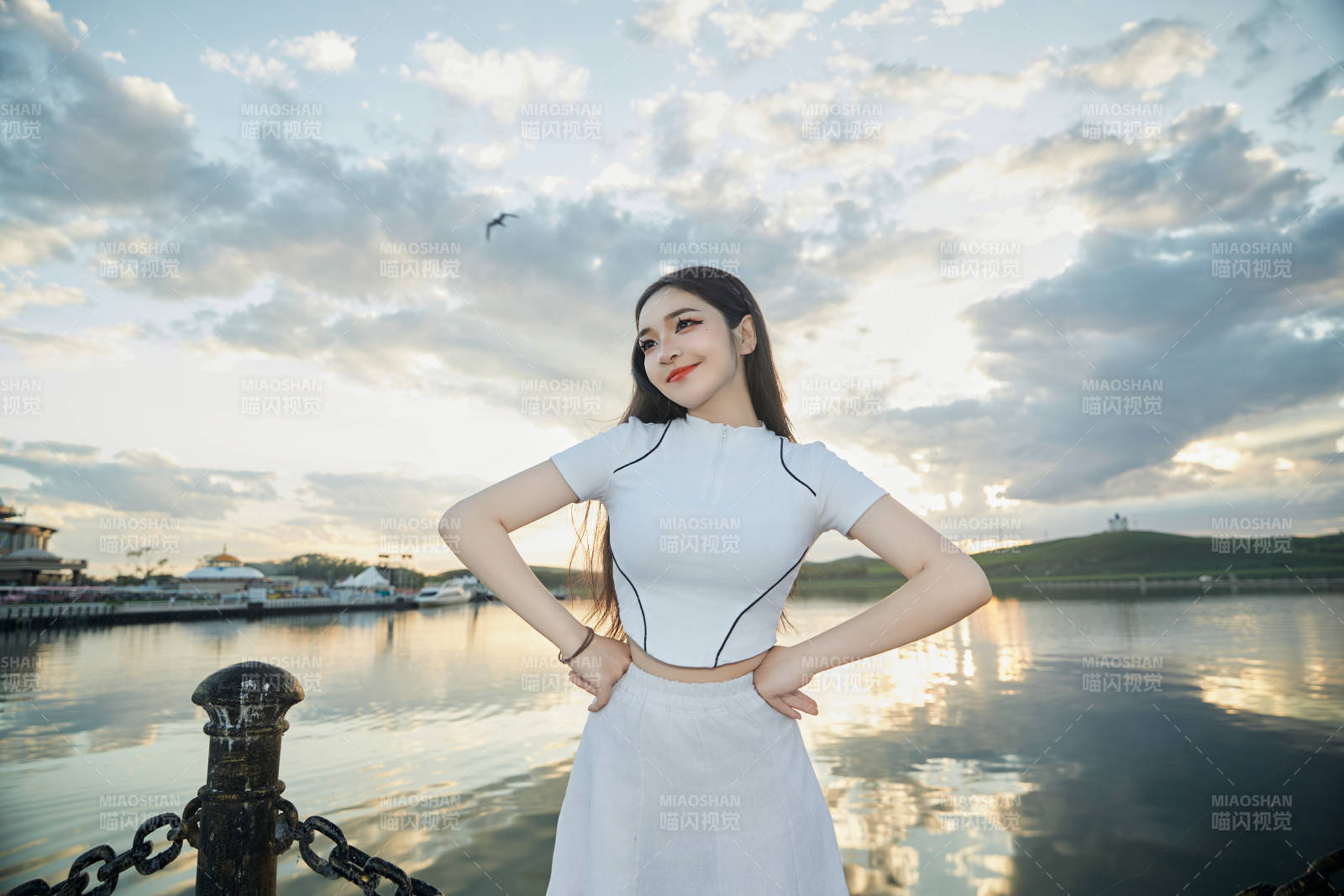 傍晚在湖边欣赏风景拍照的亚洲美女图片