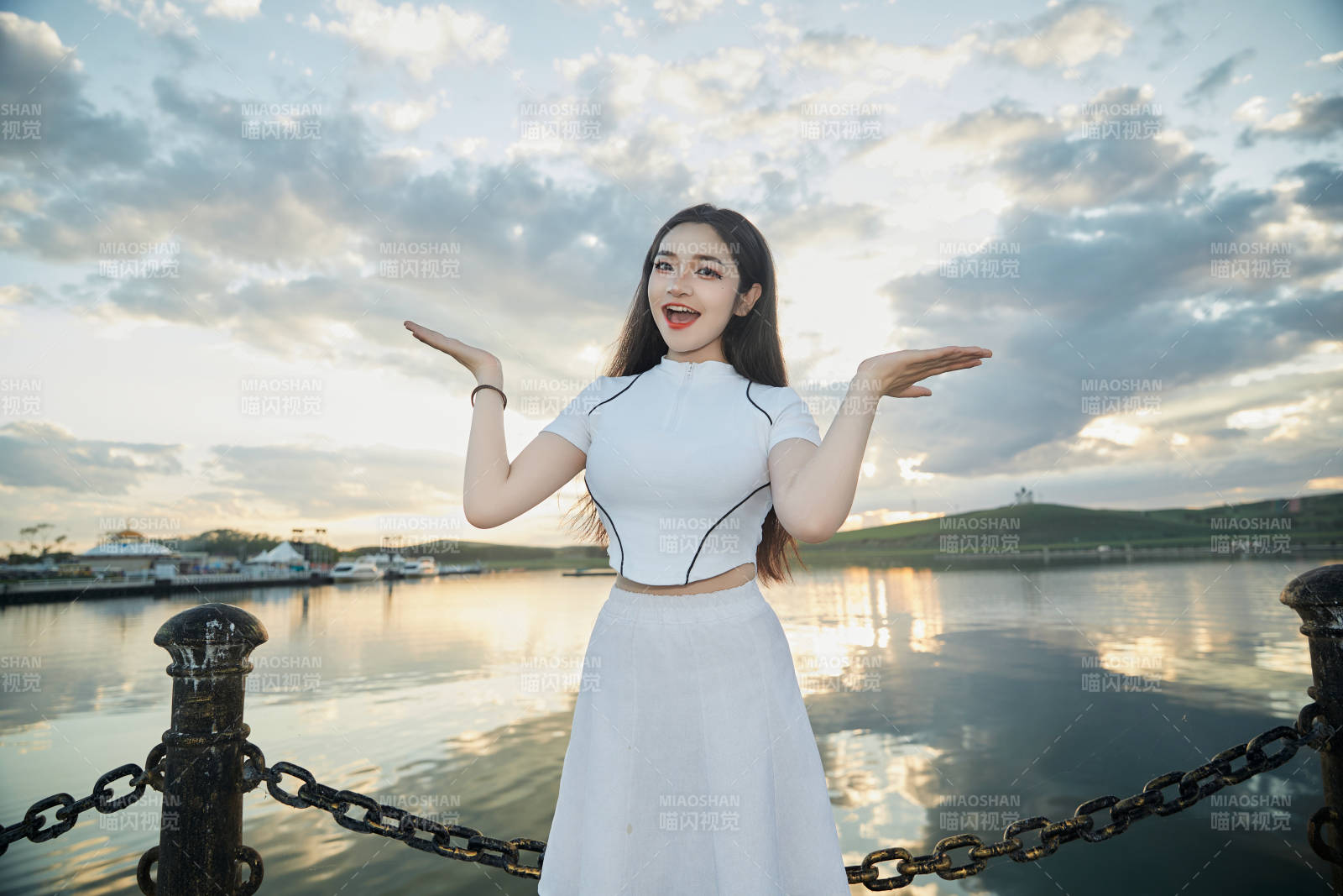 傍晚在湖边欣赏风景拍照的亚洲美女图片