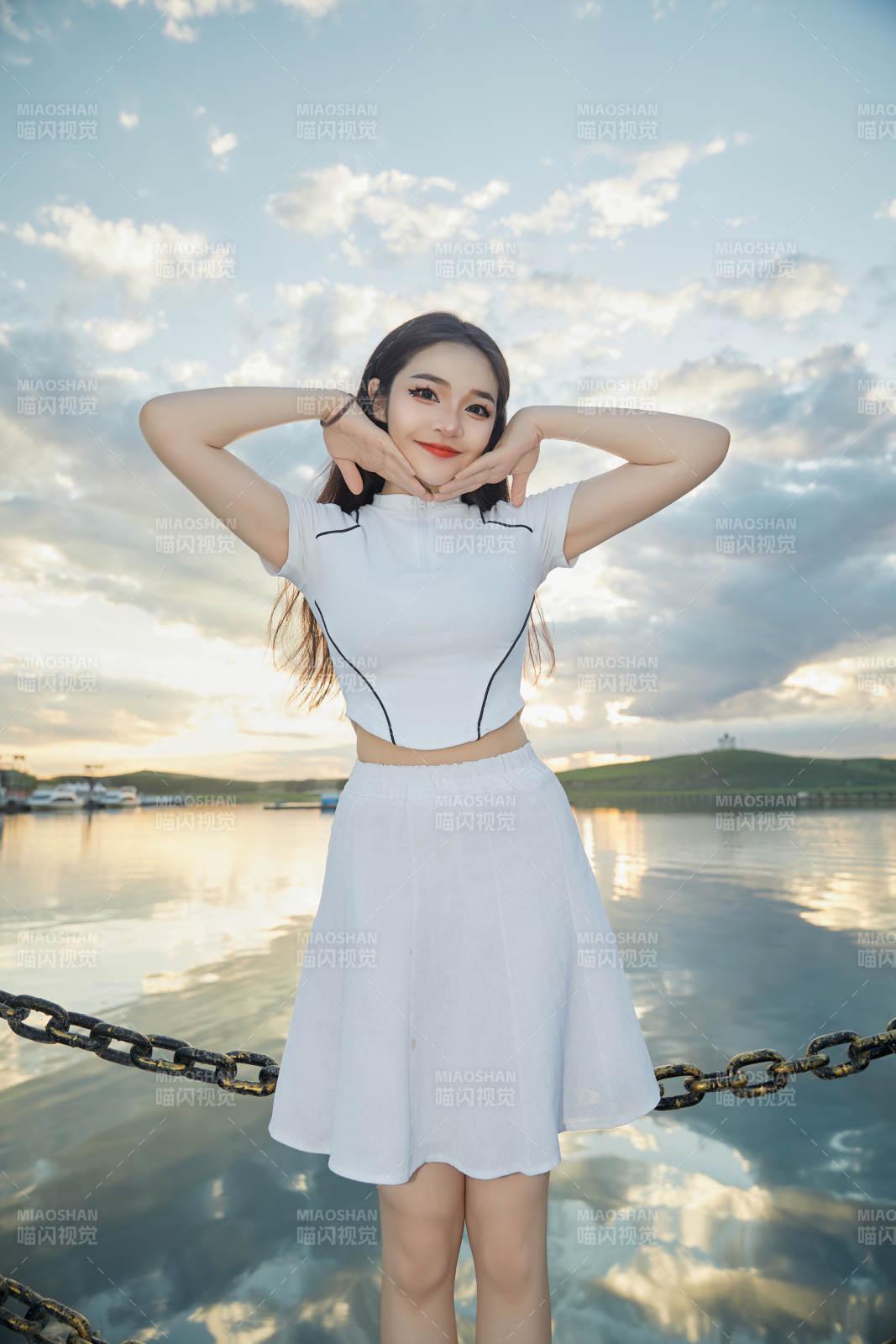 傍晚在湖边欣赏风景拍照的亚洲美女图片