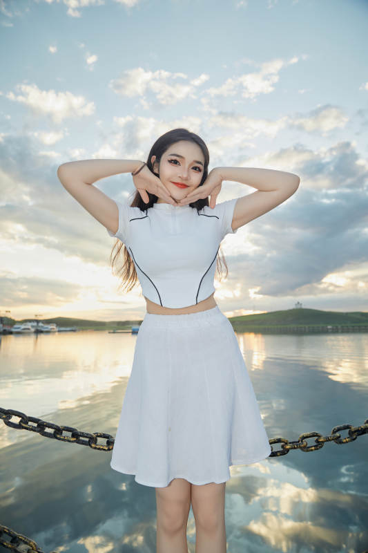 傍晚在湖边欣赏风景拍照的亚洲美女图片