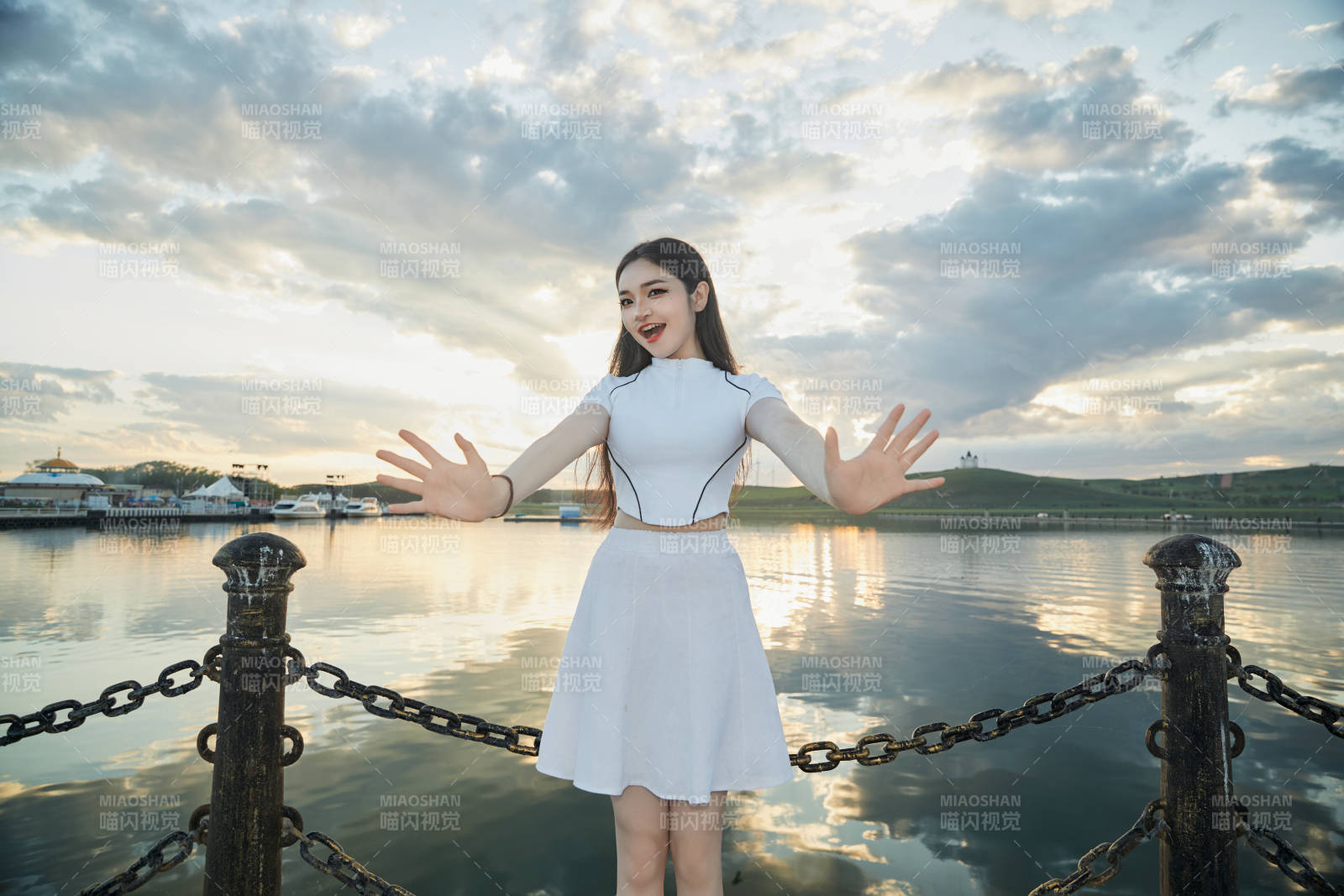 傍晚在湖边欣赏风景拍照的亚洲美女图片