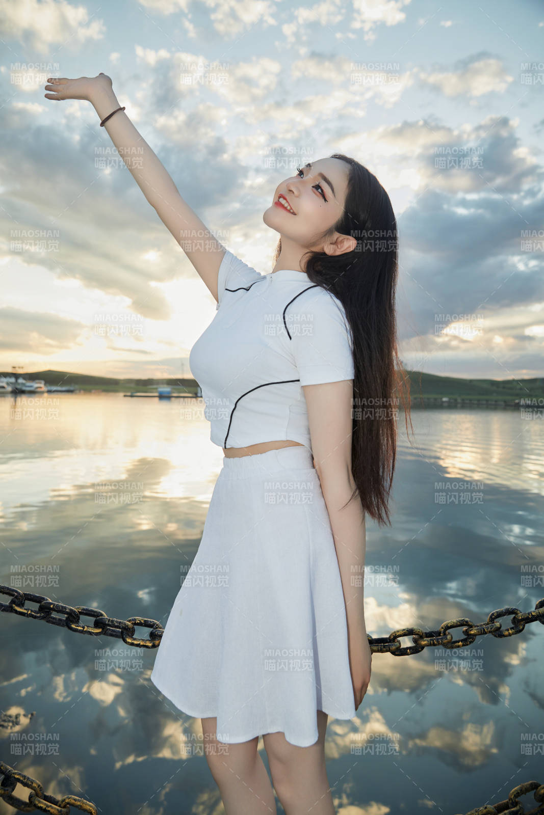 傍晚在湖边欣赏风景拍照的亚洲美女图片