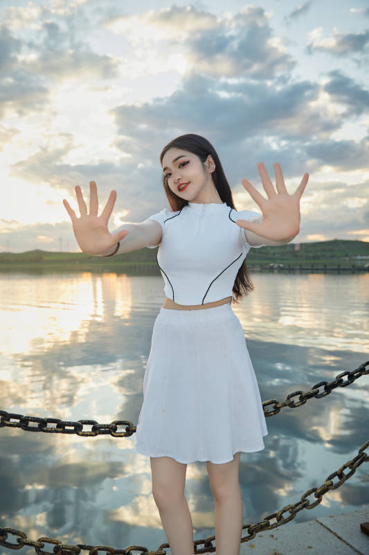 傍晚在湖边欣赏风景拍照的亚洲美女图片