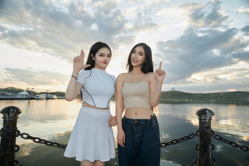 傍晚在湖边欣赏风景拍照的亚洲美女们图片