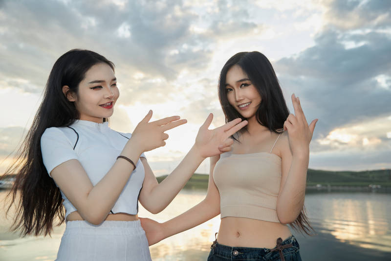 傍晚在湖边欣赏风景拍照的亚洲美女们图片