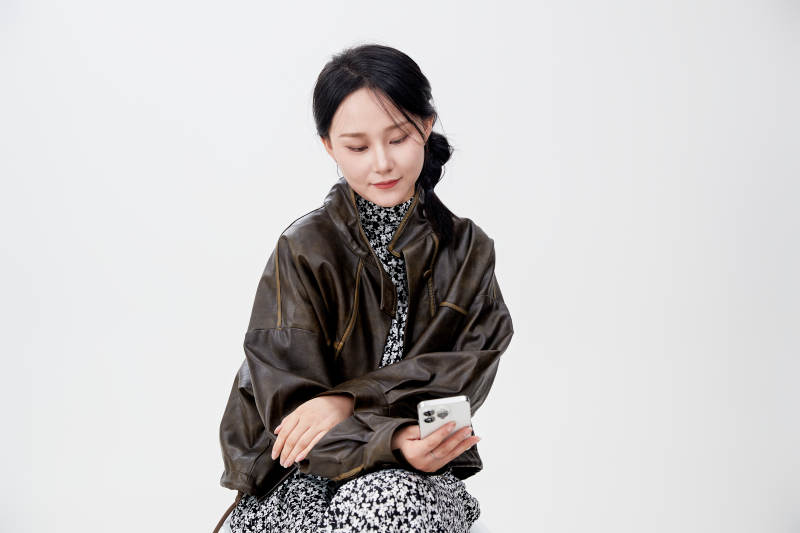 白色背景下使用手机的亚洲女性图片