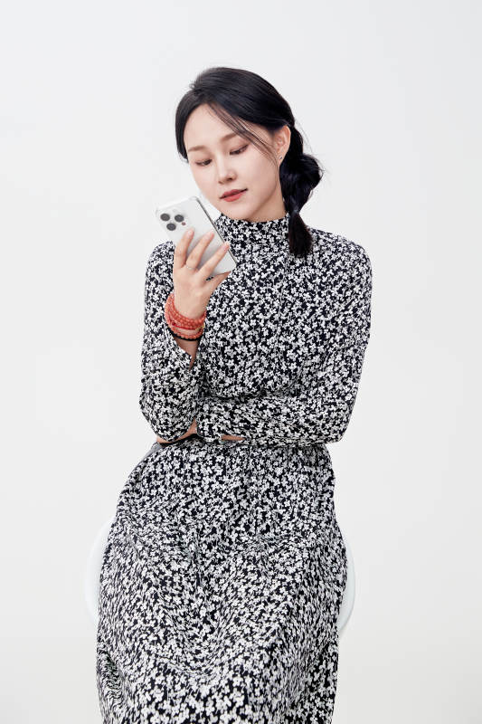 白色背景下使用手机的亚洲女性图片