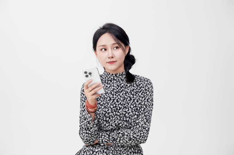 白色背景下使用手机的亚洲女性图片