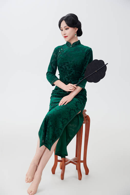 手拿纸扇身着中式旗袍坐在凳子上的美女图片