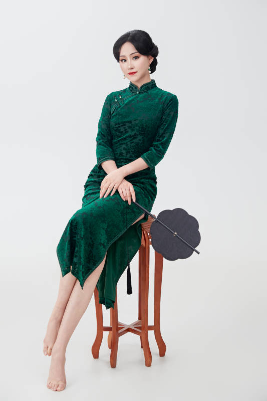 手拿纸扇身着中式旗袍坐在凳子上的美女图片