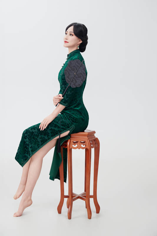 手拿纸扇身着中式旗袍坐在凳子上的美女图片