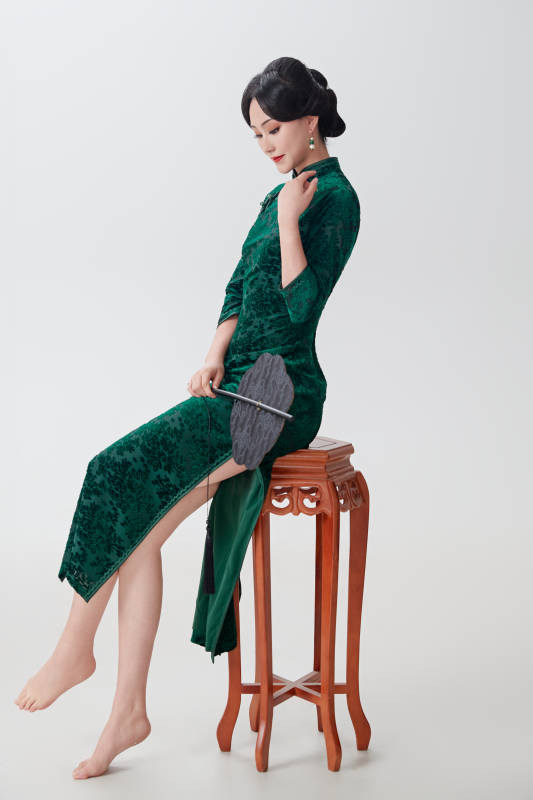 手拿纸扇身着中式旗袍坐在凳子上的美女图片